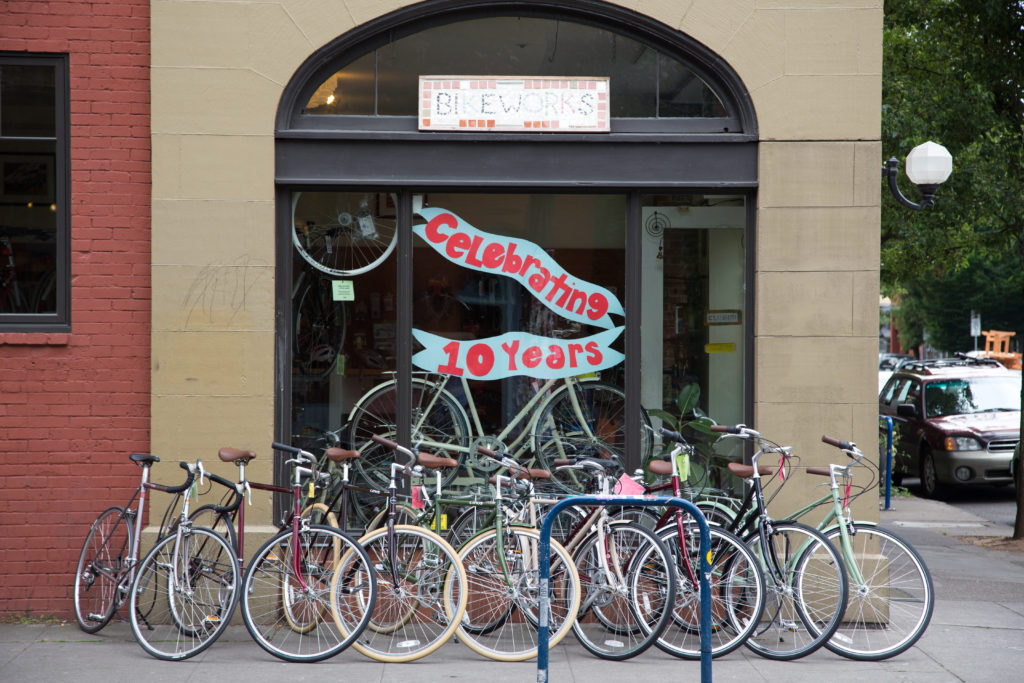 Photo provided by Travel Portland. Image shows a group of bikes in front of a bike store. 